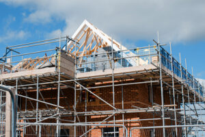 Scaffolding around a new build block of flats with sunny blue sky, flats back in demand