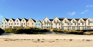 A row of houses opposite a beach, holiday lets